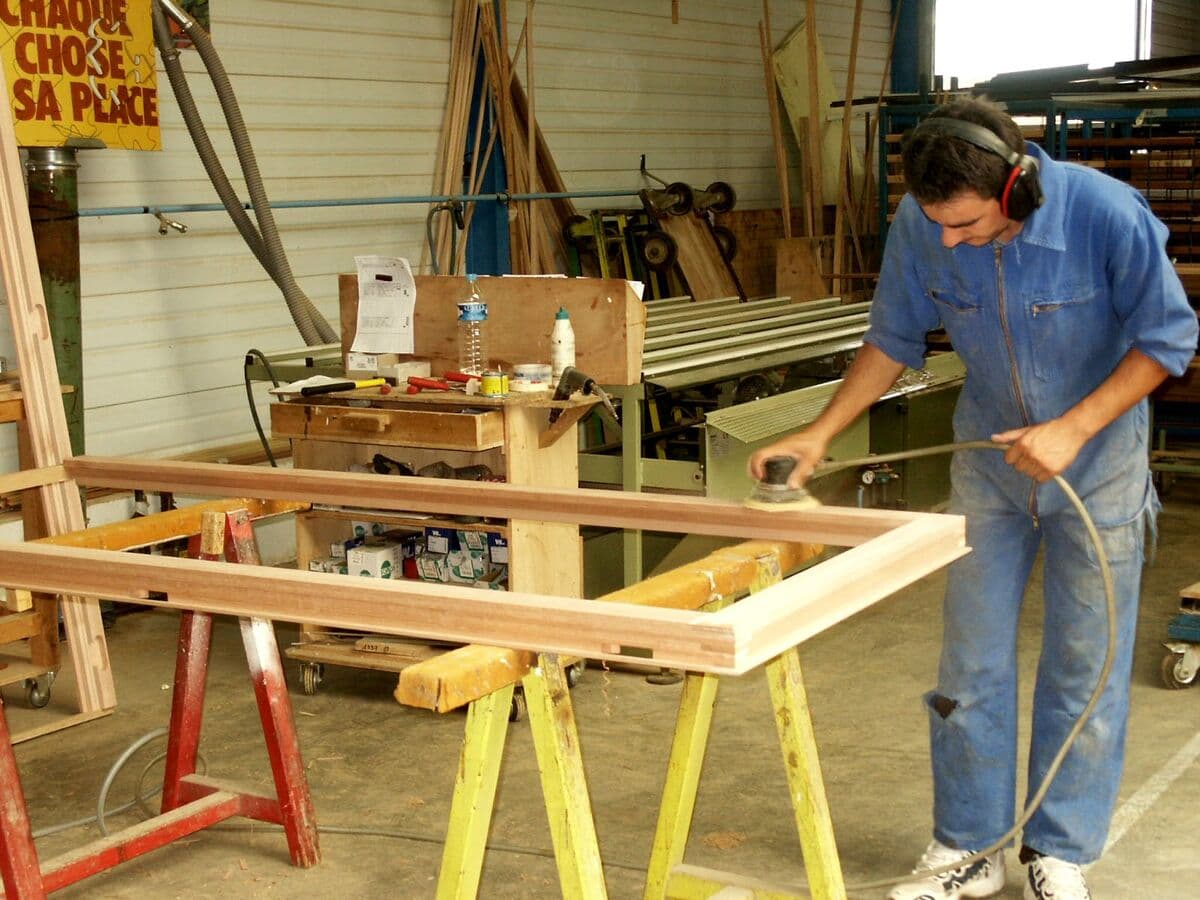 Artisan ponçant un cadre en bois